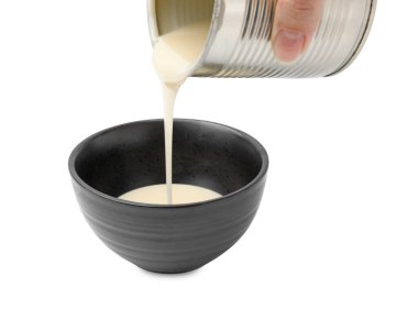 Konserve kutusundan teneke kutuya konsantre süt döken kadın, beyaz kutuya izole edilmiş, yakın plan.