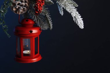 Noel feneri, köknar ağacında yanan mum ile karanlık arka planda, yakın plan. Metin için boşluk