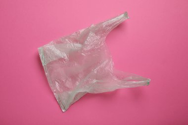 Pembe arka planda bir plastik torba, üst manzara.