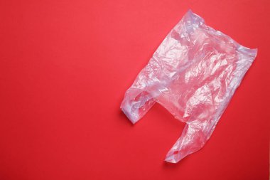 Kırmızı arka planda bir plastik torba, üst manzara. Metin için boşluk