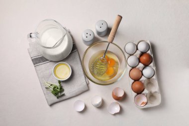 Çiğ yumurta ve çırpma kabı açık masa üzerinde düz kompozisyon