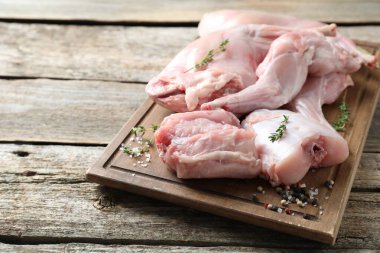 Tahta masada taze çiğ tavşan eti ve baharatlar, metin için yer.