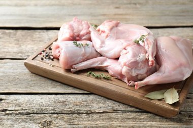 Tahta masada taze çiğ tavşan eti ve baharatlar.