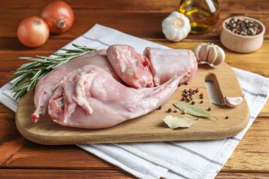 Tahta masada taze çiğ tavşan eti ve baharatlar.