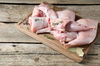 Tahta masada taze çiğ tavşan eti ve baharatlar.