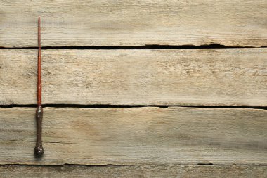 Tahta masanın üstünde eski bir sihirli değnek, üst manzara. Metin için boşluk