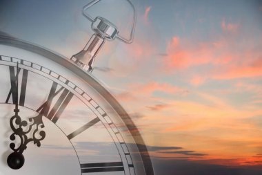 Zaman kavramı. Bulutlu gökyüzü ve saatle sabah güneşinin iki kez doğuşu