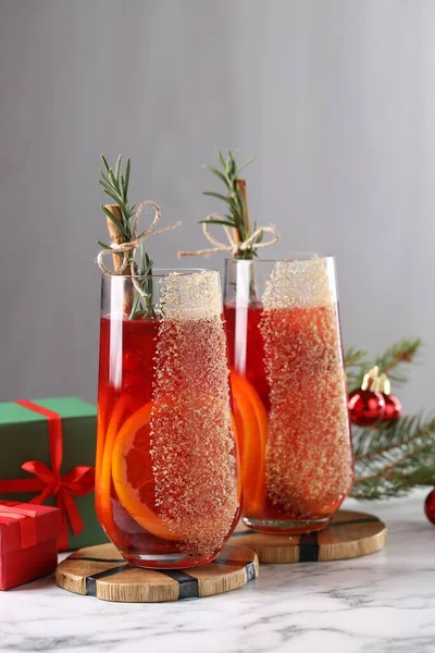 Christmas Sangria cocktail in glasses and festive decor on white marble table