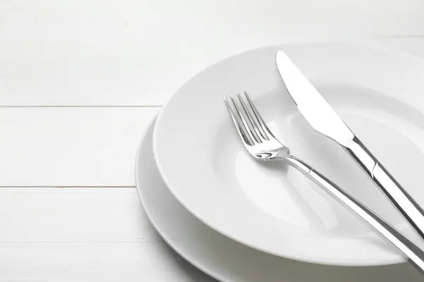 Καθαρά Πιάτα Πιρούνι Και Μαχαίρι Λευκό Ξύλινο Τραπέζι Κοντινό Πλάνο — Φωτογραφία Αρχείου