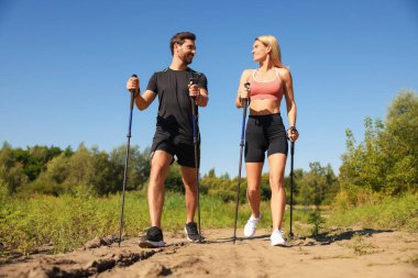 Mutlu çift, güneşli bir günde, dışarıda sırıkla yürüme alıştırması yapıyor. Düşük açılı.