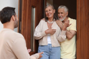 Friendly relationship with neighbours. Man visiting elderly couple