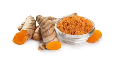 Beyaz üzerine izole edilmiş aromatik zerdeçal tozu ve ham kökleri olan bir kase.