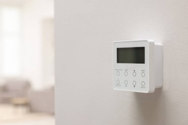 Beyaz duvarda bir termostat, mesaj için yer var. Akıllı ev sistemi