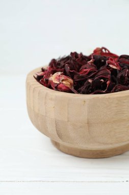 Hibiscus çayı. Beyaz ahşap masa üzerinde kurutulmuş roselle calyces ile kase, yakın çekim