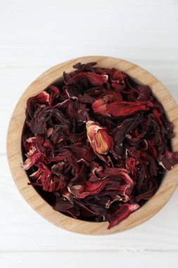 Hibiscus çayı. Beyaz ahşap masada kurutulmuş roselle calyces ile kase, üst manzara