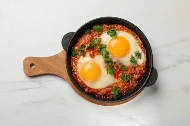 Lezzetli Shakshuka kızartma tavasında beyaz mermer masa, üst manzara