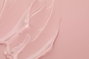 Pembe arka planda temiz kozmetik jel, üst manzara. Metin için boşluk