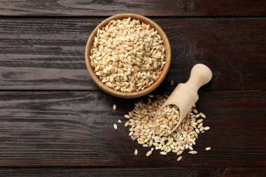 Kâsede kuru inci arpa ve tahta masada kepçe, düz. Metin için boşluk