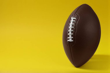 Sarı zemin üzerinde Amerikan futbol topu, metin için boşluk