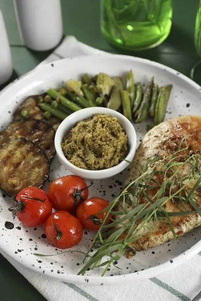 Lezzetli tavuk, tarhun ve pesto soslu sebzeler masada, yakın plan.