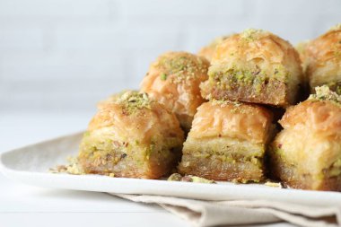 Beyaz masada doğranmış fındıklı enfes taze baklava, yakın plan. Doğu tatlıları