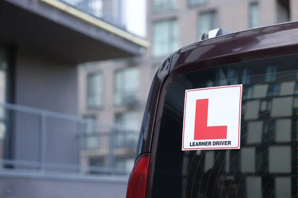 Stock image L-plate on car outdoors, closeup with space for text. Driving school