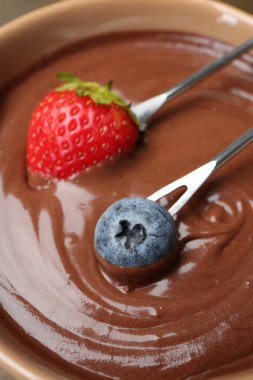 Erimiş çikolatayla fondüye daldırmak, yakın plan.