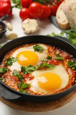 Lezzetli shakshuka tavada beyaz masada, yakın plan
