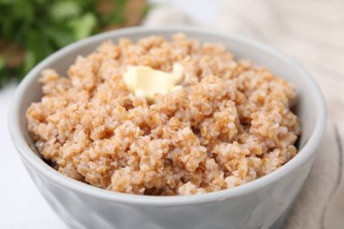 Lezzetli buğday lapası, kasede tereyağı, yakın plan.