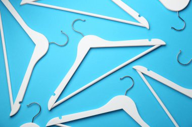 Açık mavi arkaplanda beyaz askılar, düz uzanmış