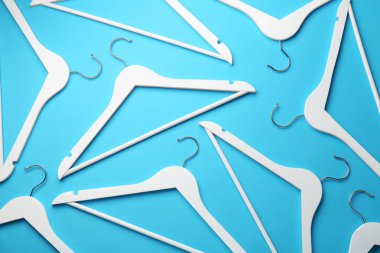 Açık mavi arkaplanda beyaz askılar, düz uzanmış