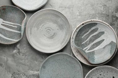 Gri masadaki seramik tabaklar düzdü.