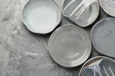 Gri masadaki seramik tabaklar düzdü. Metin için boşluk