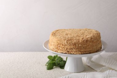 Lezzetli Napolyon keki ve nane şekeri bej masa üzerinde hafif arkaplan, metin için yer