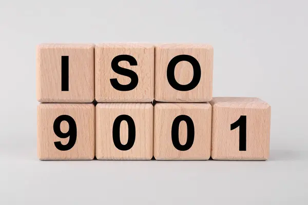 International Organization for Standardization. Wooden cubes with abbreviation ISO and number 9001 on light grey background