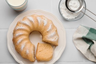 Beyaz fayanslı masada servis edilen leziz sünger keki.