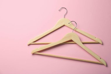 Pembe arka planda ahşap askılar, üst manzara. Metin için boşluk
