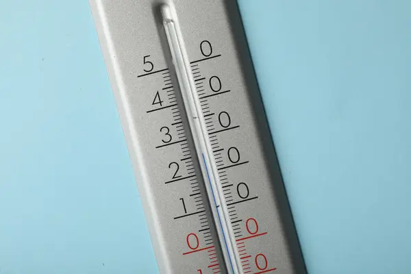 Weather thermometer on light blue background, closeup