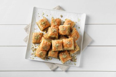 Beyaz ahşap masa üzerinde doğranmış fındıklı enfes taze baklava, üst manzara. Doğu tatlıları