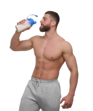 Beyaz arka planda protein karıştırıcısı tutan kaslı vücutlu genç bir adam.