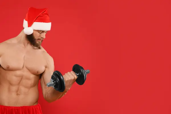 Muscular Young Man Santa Hat Dumbbell Red Background Space Text — Stock Photo, Image