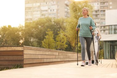 Bir grup son sınıf öğrencisi dışarıda İskandinav yürüyüşü yapıyor. Düşük açı görünümü
