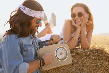 Sahada radyo alıcısı olan mutlu hippi çift.