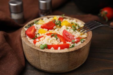 Tahta masada, kasede sebzelerle pişirilmiş bulgur, yakın plan.