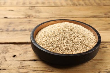 Tahta masadaki kasede kurutulmuş kinoa tohumları.