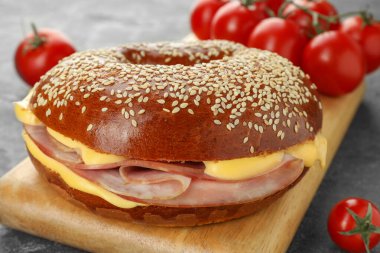 Gri masada jambonlu ve peynirli leziz simit, yakın plan.