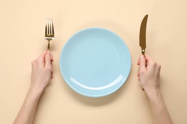 Çatal bıçaklı ve boş tabaklı kadın bej masa, üst manzara
