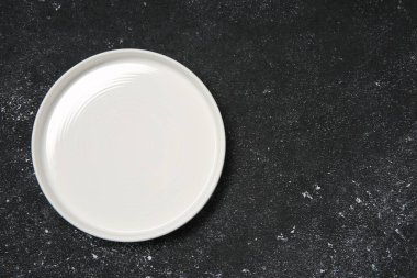 Siyah desenli tabakta bir seramik tabak, üst manzara. Metin için boşluk