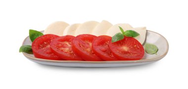 Bir tabak lezzetli Caprese salatası, domatesli, mozzarella ve fesleğenli beyaz.