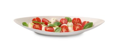 Bir tabak lezzetli Caprese salatası, mozzarella, domates, fesleğen ve pesto sosu beyaz üzerine izole edilmiş.